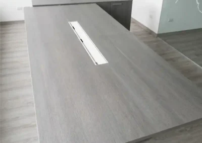 Mesa de reunión minimalista gris ceniza con pasacables invisible fabricada a medida por Tamasa.